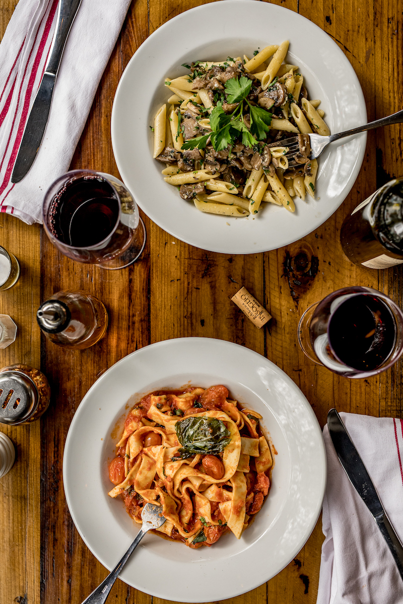 Top view of pasta dishes and wine on table