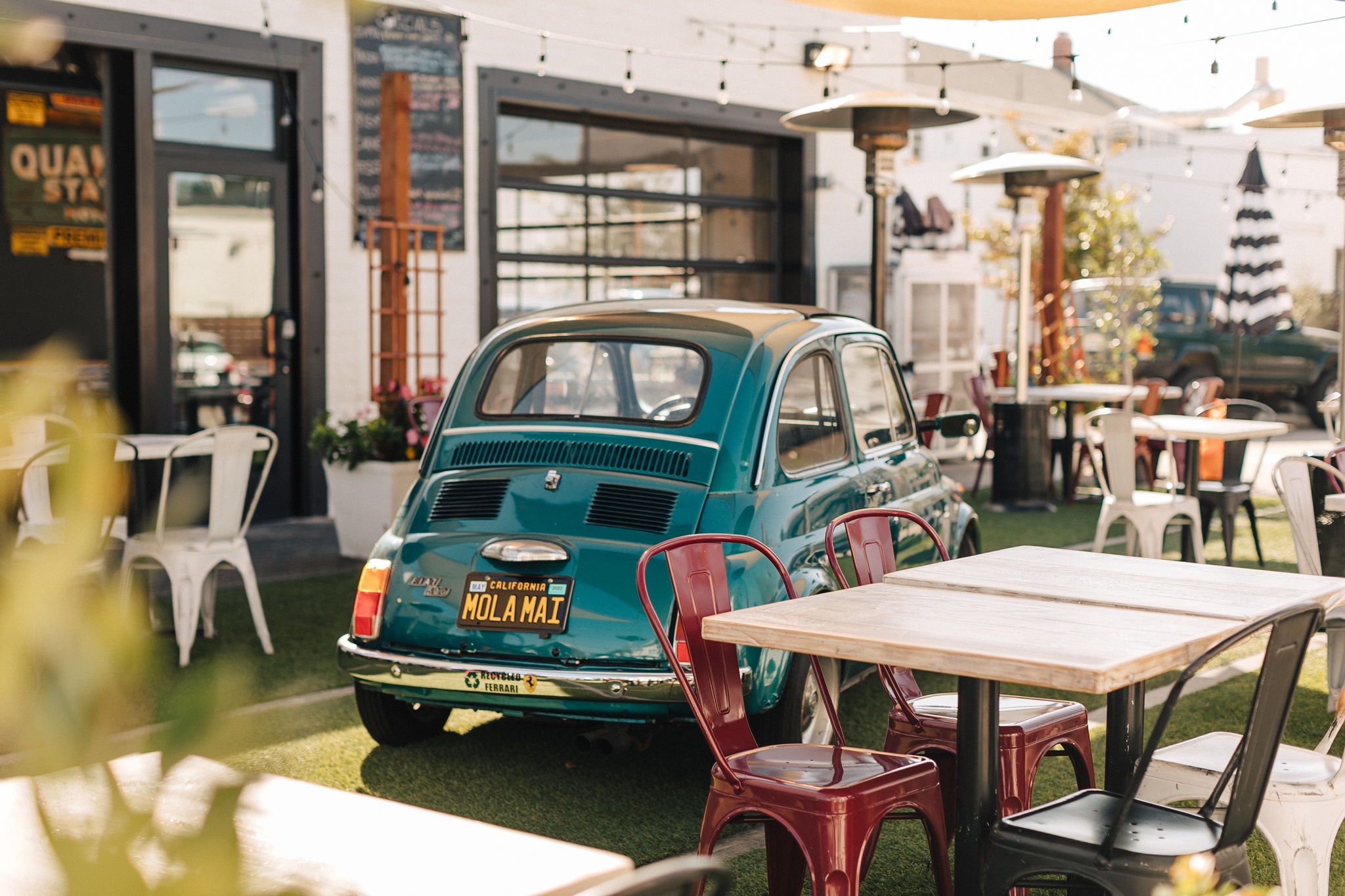 Outdoor patio with vintage car and tables