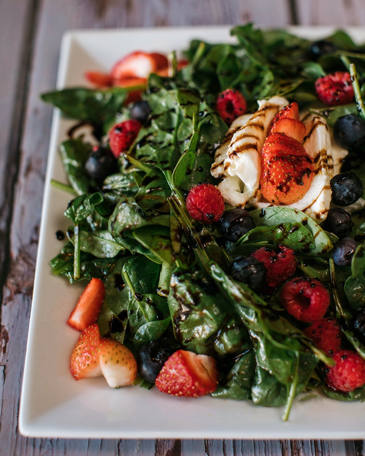 Strawberry salad with mixed greens blueberries and burrata