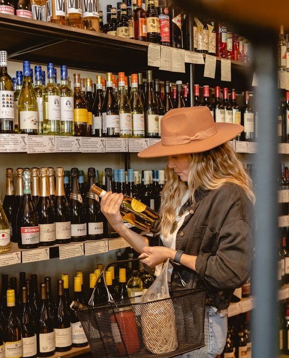 Woman looking at bottle of wine in the market