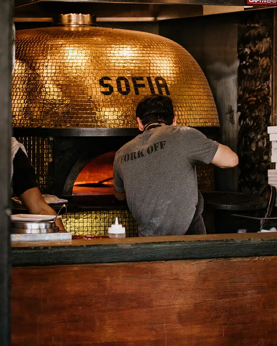 Buona Forchetta Gold Pizza oven with someone making pizza